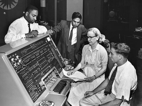 Grace Hopper sitting at the UNIVAC keyboard.